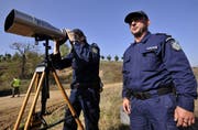 Zwei Mitarbeiter der Frontex halten Ausschau nach Flüchtlingen. (Bild: Nikolas Giakoumidis / AP)