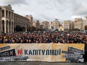 «Nein zur Kapitulation!» steht auf dem Transparent. Tausende Menschen haben am Sonntag in Kiew gegen gegen den Ostukraine-Plan der Regierung demonstriert. (Bild: KEYSTONE/EPA/SERGEY DOLZHENKO)