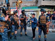Ein Strassenverkäufer im Stadtteil Sadr City von Bagdad verkauft der Polizei Kaffee. Iraks Regierungschef Adel Abdel Mahdi hatte am Montag die Armee aus dem Stadtteil abgezogen und sie durch Polizisten ersetzt. (Bild: KEYSTONE/AP/HADI MIZBAN)