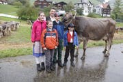 Der neuen «Miss Krinau» ist der Regen sichtlich verleidet. Hans Brunner mit seinen Kindern Silvan, Jasmin, Damian und Adrian (Buben nach Grösse!) freuen sich über den Missentitel ihrer Kuh Fink. (Bild: Fränzi Göggel)
