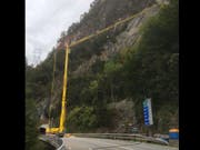 Mit Hilfe eines Pneukrans werden am Axen beschädigte Steinschlagschutznetze repariert. (Bild: Astra)