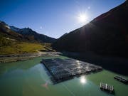Auf dem Stausee Lac des Toules im Wallis werden 36 schwimmende Photovoltaik-Elemente zu einer Solarenergieanlage zusammengebaut. Diese Pilotanlage bedeckt eine Fläche von 2240 Quadratmetern und wird jährlich 800'000 Kilowattstunden Strom für 220 Haushalte produzieren. (Bild: KEYSTONE/VALENTIN FLAURAUD)
