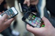 Jugendliche mit ihren Mobiltelefonen und den dazugehörenden Apps. (Bild: Keystone/Christian Beutler)
