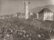 Eine der Glocken schwebt vor 60 Jahren am neu erstellten und mit Fahnen geschmückten Glockenturm im Grossacker in die Höhe. Viel Publikum wohnte dem Glockenaufzug bei. Und das Lager mit den Telefonstangen am heutigen Standort des Einkaufszentrums Grossacker wurde zur Tribüne. (Bild: Sammlung Johannes Rutz - 25. November 1959)