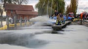 Die Einsatzkräfte der Freiwilligen Feuerwehr in Zug streuen Ölbinder ins Wasser. (Bild: Freiwillige Feuerwehr Zug, 2. November 2019)