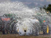 Französische Bauern sprühen aus Protest gegen fallende Preise Milch auf ein Feld. (Bild: KEYSTONE/AP/BOB EDME)