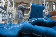 Eine Mitarbeiterin in der Spulerei der Textilfabrik Lantal Textiles AG. (Bild: Marcel Bieri/Keystone, Melchnau, 21. März 2016)