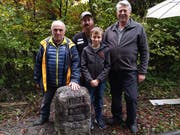 Walter Rohner (links) freut sich über die Neusetzung des Grenzsteins an seinem Grundstück. Dieser wurde auf dem Land von Adrian, Alex und Silvan Steiner in Baar gefunden. (Bild: Sabine Windlin/PD)