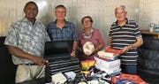 Schumachers mit dem Schuldirektor Francis, sie bringen Laptops und Schulmaterial. (Bild: PD)