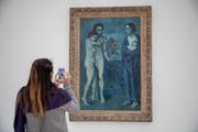 Eine Frau betrachtet "La Vie" von Pablo Picasso. Es ist Teil der "Blauen Periode" des spanischen Malers. Die Trauer des jungen Künstlers legt sich wie ein Schleier über das Bild. (Bild: Keystone)