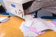Ein Mitarbeiter des Auszählbüros öffnet die Urne und leert die Listen aus. (Bild: Roger Grütter, Luzern, 5. Juni 2016)