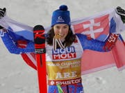Petra Vlhova, das Gold zwischen den Zähnen, präsentiert sich stolz mit der slowakischen Flagge (Bild: KEYSTONE/EPA/VALDRIN XHEMAJ)