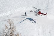 Ein Helikopter der Air Glacier gestern über der Unglücksstelle: Die Suche nach möglichen weiteren Verschütteten wurde gestern Vormittag eingestellt. (Bild: Jean-Christophe Bott/Keystone; Crans-Montana, 20. Februar )