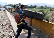 Zivilisten versuchen, auf der Grenzbrücke Simón Bolívar den Weg freizumachen für humanitäre Transporte von Kolumbien nach Venezuela. Bild: Ernesto Guzman/EPA (Cúcuta, 24. Februar 2019)