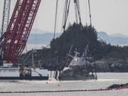 Mit Spezialkränen wird das norwegische Kriegsschiff «Helge Ingstad» in einem Hafen im Norden von Bergen aus dem Wasser gehoben. (Bild: Keystone/AP NTB Scanpix/VIDAR RUUD)