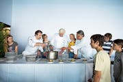 Zuger Schüler kochen im Rahmen des Genuss-Film-Festivals gemeinsam mit den Köchen Peter Bechter (links), Stefan Meier (Mitte) und Edi Hitzberger, nachdem sie sich einen Film zum Thema «Slow Food» im Kino Seehof angeschaut haben. (Bild: Maria Schmid, Zug, 7. Mai 2018)