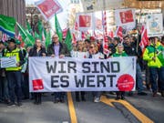 Demonstranten gehen am Dienstag beim Warnstreik mit einem Banner mit der Aufschrift «Wir sind es wert» durch die Münchener Innenstadt. Die Gewerkschaft Verdi hat mehr als 2000 Beschäftigte im Öffentlichen Dienst in ganz Bayern zu Warnstreiks gerufen. (Bild: Keystone/DPA/LINO MIRGELER)