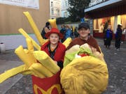 Hamburger und Pommes Frites: Diesen zwei jungen Fasnächtlern schmeckt's in Luzern. (Bild: Kilian Küttel)