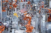Roboter von ABB fertigen in einer Werkshalle Lastwagentüren. (Bild: Sven Hoppe/Keystone (München, 16. Mai 2018))