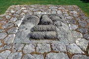 Ein Gesicht mit den künstlerischen Zügen, wie sie für Rudolf Blättler typisch sind, schaut aus dem Erdboden hinauf in den Himmel. (Bild: Andreas Faesser (Rotkreuz, 24. April, 2018))