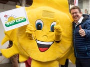 SVP-Parteipräsident Albert Rösti posiert zusammen mit dem Partei-"Sünneli» beim Wahlkampfauftakt in Aarwangen BE. (Bild: KEYSTONE/PETER KLAUNZER)