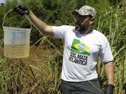 Ein Biologe der Umweltorganisation SOS Mata Atlantica mit einer Wasserprobe aus dem Fluss Paraopeba, dessen Leben durch den Dammbruch zerstört wurde. (Bild: Keystone/AP/ANDRE PENNER)