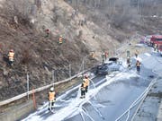 Die Feuerwehrleute mussten nicht nur den Autobrand löschen, sondern auch die Flammen auf der Böschung. (Bild: Kapo GR)