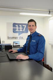 Jürg von Gunten, Kommandant der Nidwaldner Kantonspolizei, in seinem Büro in Stans. Im Hintergrund das 117-Bild, das aus einem Mosaik mit allen Mitarbeiterporträts besteht. (Bild: Philipp Unterschütz, 11. März 2019)