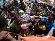 Aus den Trümmern des eingestürzten dreistöckigen Gebäudes in Lagos wird ein Kind geborgen. (AP Photo/Sunday Alamba) (Bild: KEYSTONE/AP/SUNDAY ALAMBA)