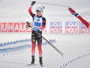 Johannes Thingnes Bö muss zum Schluss nicht spurten, sondern er schwingt Norwegens Fahne. (Bild: KEYSTONE/EPA TT NEWS AGENCY/JESSICA GOW)
