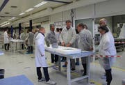 Im sterilen Reinraum der Evatec werden auch die Besucher zu Weisskitteln. (Bild: Hans Hidber)