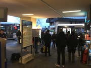 Pendlerinnen und Pendler warten beim Bahnhof auf ihre Bahnersatzbusse. (Bild: David von Moos, Hergiswil, 18. März 2019)