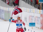 So überlegen, dass sie mit der norwegischen Flagge ins Ziel laufen konnte: Weltmeisterin Therese Johaug (Bild: KEYSTONE/PETER SCHNEIDER)