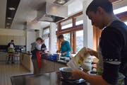 Bitte nichts verschütten: Die Schüler gehen beim Kochen des Mittagsmenus konzentriert ans Werk. Bild: Nicola Ryser