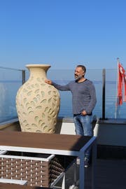 Pächter Zeki Ok zeigt stolz die Aussicht auf dem Balkon im ersten Stock des Seerestaurants. Mannshohe, vasenförmige Lampen sollen bei Dunkelheit für ein gemütliches Ambiente sorgen. (Bild: Martin Rechsteiner)