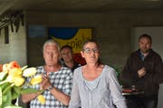 Marianne Burger Studer und ihr Mann Hans-Jörg Studer (links) freuen sich am Wahl-Apéro vor der Turnhalle in Lütisburg. Der unterlegene Werner Scherrer (hinten rechts) klatscht mit. (Bild: Timon Kobelt)