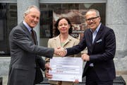 Spendenübergabe vor der Tourist Information (von links): Jan Poëll und Karin Fagetti von Cheira sowie Tourismusdirektor Thomas Kirchhofer. (Bild: PD)