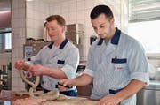 Gabriel Nauer (links) und Davide Vailati verarbeiten das Schweinefleisch zur Mörschwiler Kräuterbratwurst. (Bild: Judith Schönenberger)