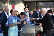 Die Stadträte Erwin Tanner, Stefan Koster und Daniela Di Nicola stehen hinter dem Grill und verteilen Bratwürste. (Bild: Manuel Nagel)