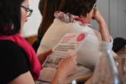 Eine Teilnehmerin am Zentrum-Znüni begutachtet einen ersten Entwurf der Baustellenzeitung. (Bild: Ruben Schönenberger)