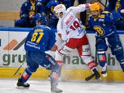 Die Davoser Anton Rödin (links) und Andres Ambühl nehmen den Rapperswiler Dion Knelsen in die Zange (Bild: KEYSTONE/PPR/JUERGEN STAIGER)