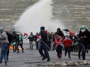 Erneute Eskalation: Palästinensische Demonstranten fliehen am Samstag vor Tränengas der israelischen Sicherheitskräfte. (Bild: KEYSTONE/EPA/ALAA BADARNEH)