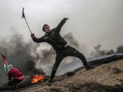 David gegen Goliath: Palästinensische Jugendliche schleudern Geschosse über den Grenzzaun des Gazastreifens gegen israelische Soldaten. (Bild: KEYSTONE/EPA/MOHAMMED SABER)