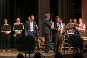 EKS-Geschäftsführer Dani Müller überreicht Philipp Langenegger als Dank für die gelungene Moderation des Jubiläumsanlasses einen Käse. Links Roger Greutmann, Präsident des EKS-Stiftungsrates. Bild: Leo Graf
