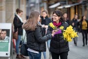 Internationaler Frauentag 2018: Andrea Hornstein von der Politischen Frauengruppe (PFG) verteilt auf dem Bärinnenplatz Mimosen an Passantinnen. Der Brauch stammt aus dem Süden, wo die Mimosen eine er ersten Blumen ist, die im Frühling üppig blüht. (Bild: Michel Canonica - 8. März 2018)