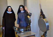 Schwester Scholastika Beyeler (links) und Frau Mutter Gabriela Tinner vom Tübacher Kloster an den Hostienbackeisen, die noch bis Ende 2018 in Betrieb waren. (Bild: PD)