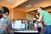 Dirigiert von Martin Seiterle und begleitet am E-Piano von Carina Felix singen die Kindergärtler den Gästen ihr «Mühlebacher Lied» im Mehrzwecksaal im oberen Stock des neuen Gebäudes.