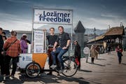 André Bachmann und Philippe Stutz (links) von der IG Weltoffenes Luzern auf dem Velo mit integriertem Briefkasten am Rathausquai. (Bild: Pius Amrein, Luzern, 1. April 2019)