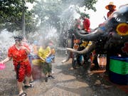 Nasse Neujahrsgrüsse vom Dickhäuter: Elefanten besprühen Passanten an Songkran in Ayutthaya, Thailand. (Bild: KEYSTONE/EPA/RUNGROJ YONGRIT)