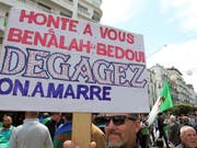 «Wir haben Euch satt - haut ab» steht, an die Machthaber gerichtet, auf einem Schild, das Protestierende an der Freitagsdemonstration in der algerischen Hauptstadt mit sich führen (Bild: KEYSTONE/AP/FATEH GUIDOUM)